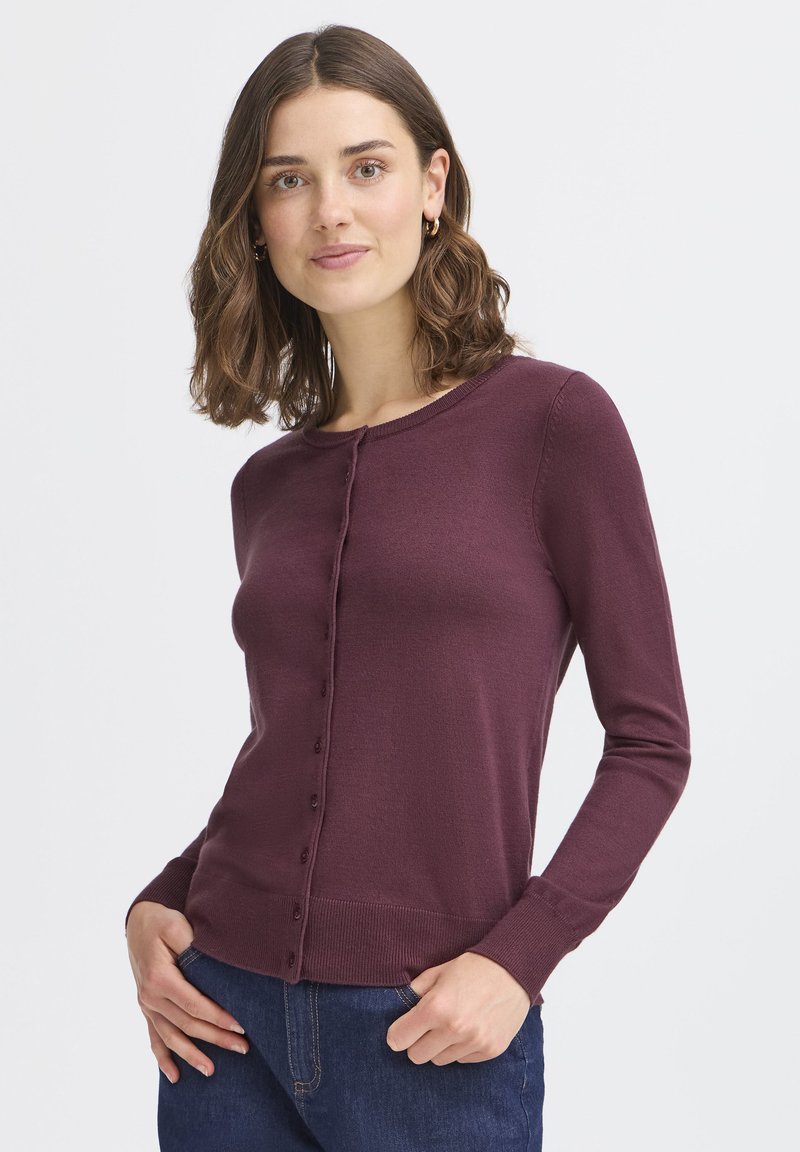 Burgunderfarbener Cardigan mit rundem Ausschnitt, langen Ärmeln und einer vorderen Knopfleiste. Rippstrick-Details an den Bündchen und dem Saum. Weiche Textur.