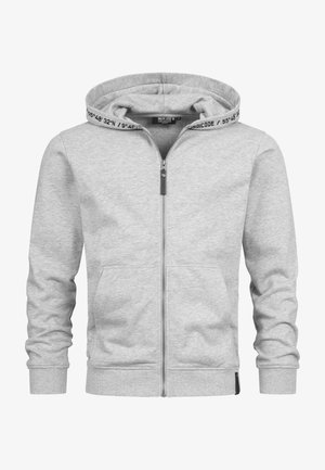 Felpa grigia con zip, cappuccio regolabile con stringhe, tasche laterali e polsini a costine. Presenta una scritta all'interno del cappuccio e una texture di tessuto liscia e morbida.