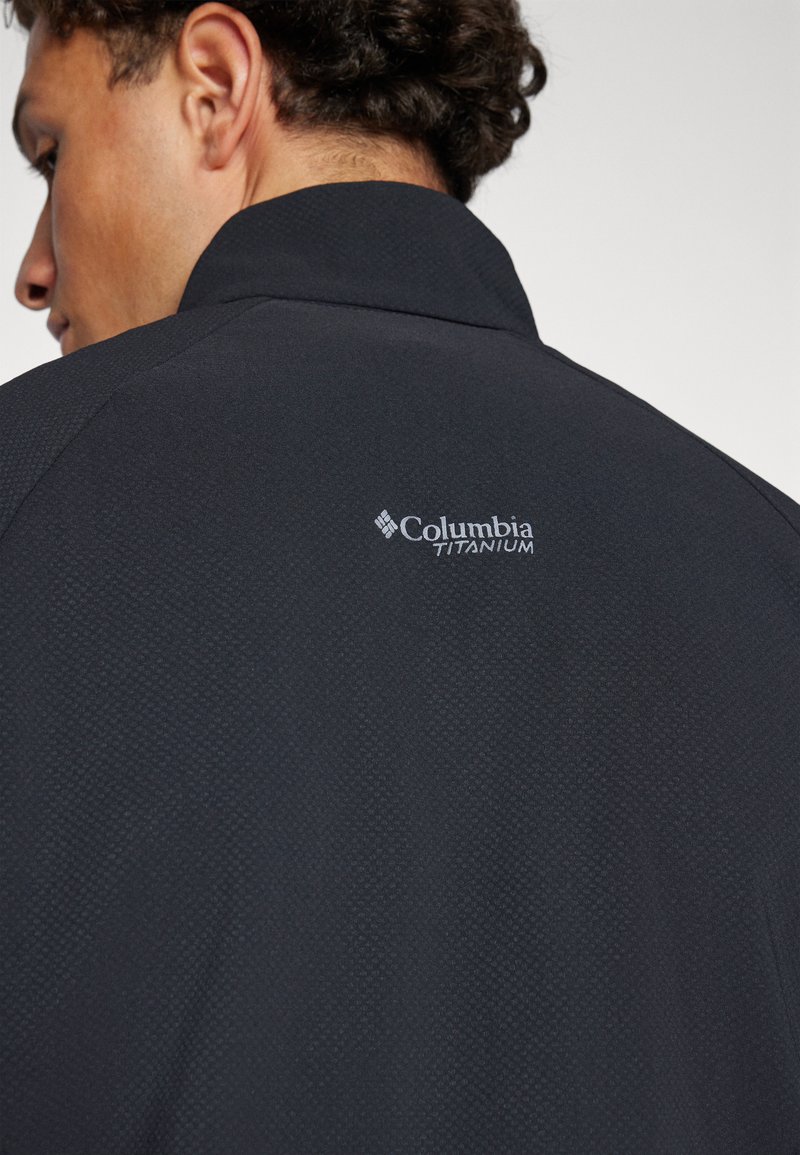 Schwarze Columbia Titanium Jacke aus strukturiertem Material, mit hohem Kragen und dezentem Branding auf der Rückseite.