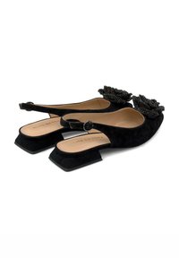 Chaussures slingback en daim noir avec un talon carré et un accent floral en perles sur l'orteil. Intérieur lisse et sangle à boucle réglable.