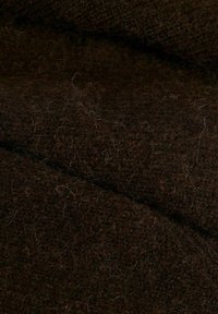 Brauner Wollstoff mit einer weichen, strukturierten Oberfläche, die feine Fasern und ein leicht flauschiges Aussehen aufweist. Das Material ist dicht und warm.