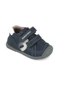 Scarpa per bambini in blu navy con esterno in pelle liscia, due cinturini regolabili in Velcro, suola grigia e dettagli bianchi sul tallone e sul logo.
