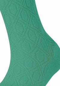 Grüne gemusterte Socke mit einem strukturierten Strickdesign aus Rautenformen und gerippten Details, die ein glattes, dehnbares Material hervorhebt.