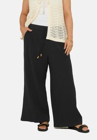 Zwarte wijde broek van lichtgewicht stof, met een elastische tailleband met koord en twee zijzakken.