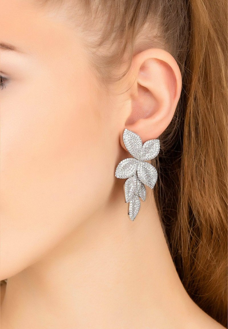 Silver floral earrings with multiple petal-like shapes, encrusted with sparkling gemstones, featuring a textured surface and elegant design.