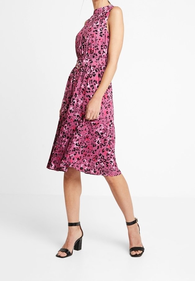 Robe midi rose sans manches à imprimé léopard avec ceinture, portée avec des sandales à talons carrés noires à bride cheville et orteils ouverts.