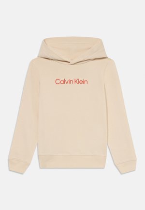 Kreminės spalvos medvilninė hoodie su klasikiniu dizainu, kuriame yra raudonas logotipas priekyje, ilgomis rankovėmis ir su raišteliu reguliuojama kapu.
