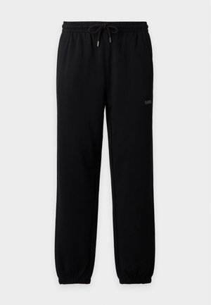 Čierne elastické nohavice jogger sťahovacie šnúrkou, bočné vrecká, elastické manžety a malé logo "RAINS" na pravom stehne.