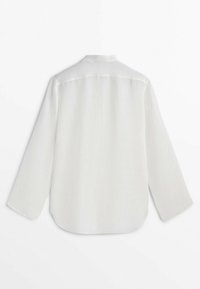 Chemise blanche à manches longues avec un col simple, vue de dos sur un fond blanc uni.