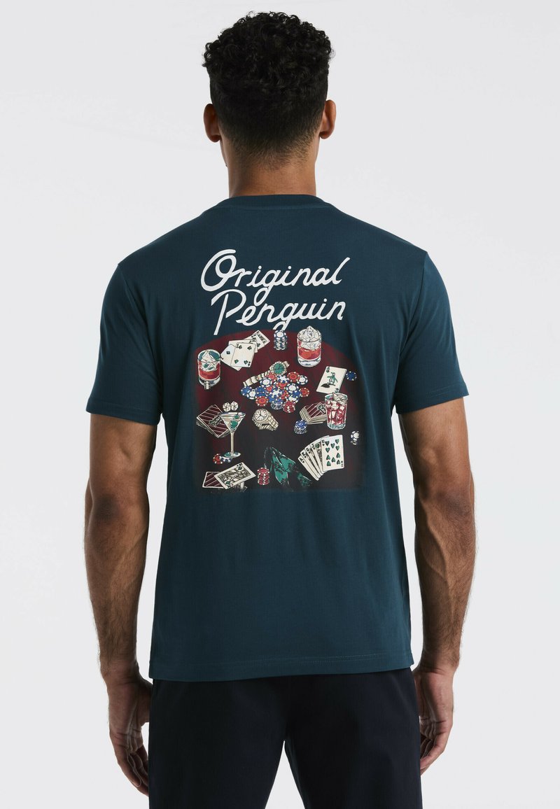Navyblauwe T-shirt met korte mouwen met een kleurrijke grafische print van kaarten, dobbelstenen en drankjes op de achterkant, gelabeld "Original Penguin."
