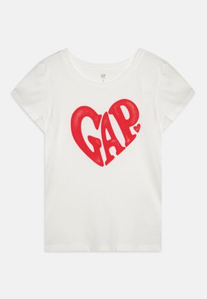 White cotton t-shirt featuring a large red heart graphic with the word "GAP" in bold lettering. Short sleeves and a round neckline.