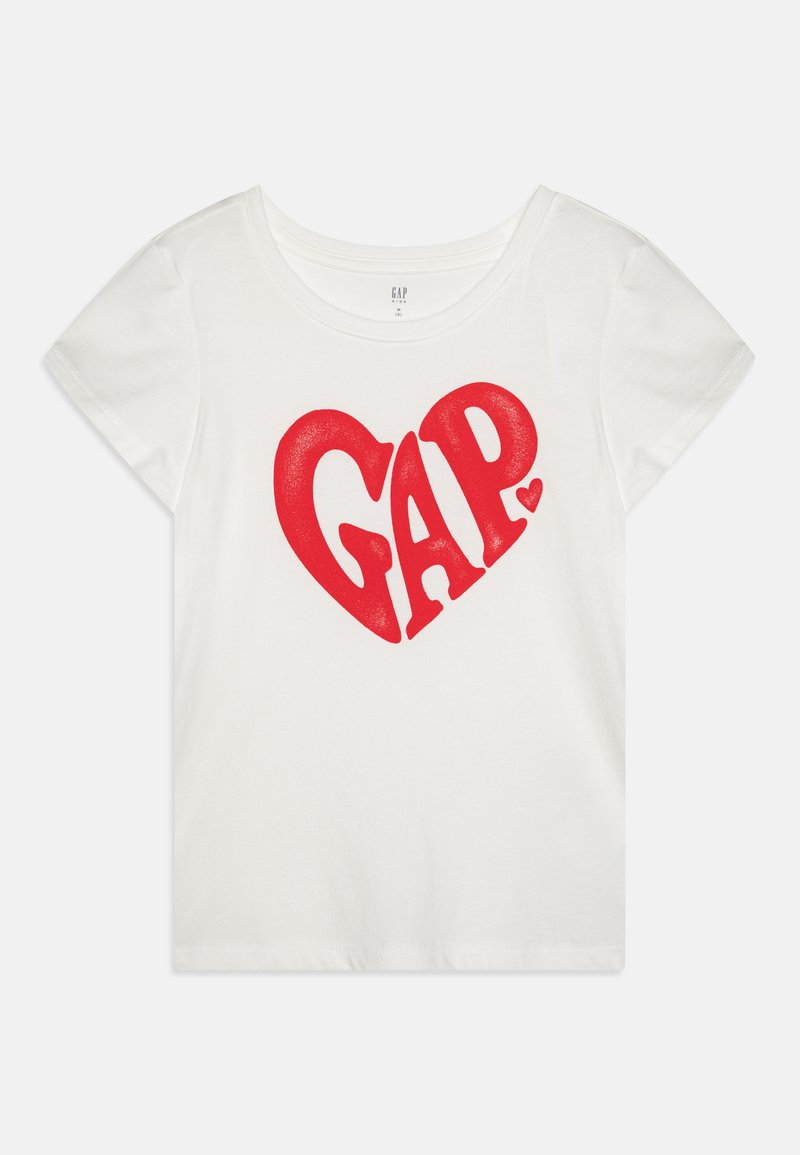 T-shirt de algodão branco com um grande gráfico de coração vermelho e a palavra "GAP" em letras negritas. Mangas curtas e decote redondo.