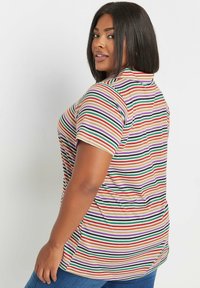 Randig kortärmad t-shirt i beige med gröna, röda, lila och orange ränder; avslappnad passform och design på ryggen för komfort.