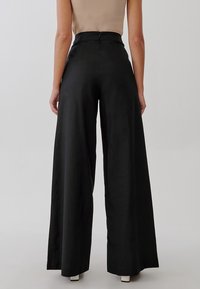 TUSSAH Kalhoty - black