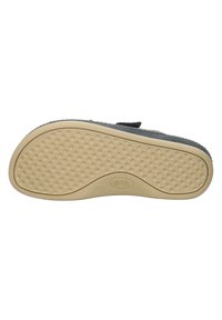 Semelle de chaussure noire en caoutchouc texturé pour une adhérence optimale, dotée d'une couleur beige contrastante et d'une empreinte de logo. Design léger et flexible.
