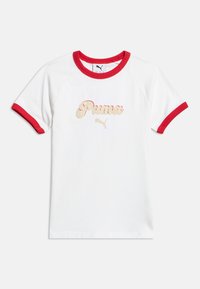 Λευκό κοντομάνικο μπλουζάκι με κόκκινο γιακά και μανσέτες, με μπεζ και κόκκινο λογότυπο Puma και εικονίδιο πάνθηρα στο κέντρο του στήθους.