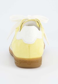 Žluté semišové tenisky s bílými koženými detaily, kulatá špička, plochá podrážka a šněrování v přední části. Na patě je vyraženo "Paul Green".