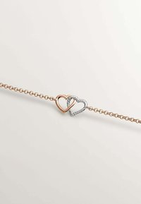 Pulsera de corazón en oro rosa y plata con diseño entrelazado; presenta un corazón liso de oro rosa y un corazón trenzado texturizado de plata en una cadena.