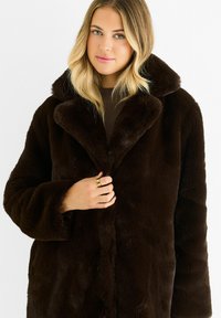 Brown faux fur coat with a wide collar, long sleeves, and a soft texture, featuring a button closure and a relaxed fit.