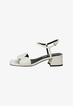 Sandal in pelle bianca con punta quadrata, ampia fascia frontale con design floreale, cinturino alla caviglia regolabile e tacco basso a blocco.