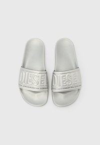Srebrne papuče na platformu od sintetičkog materijala s teksturiranim remenom na kojem je istaknuti logotip "DIESEL" i fraza "FOR SUCCESSFUL LIVING."
