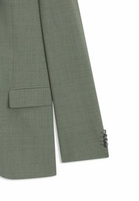 Ein einreihiger Blazer aus olivgrünem Stoff mit Reverskragen, Seitentasche und drei dunklen Knöpfen an den Manschetten. Glatte Textur.