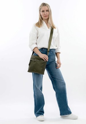 Olive green crossbody bag made of durable fabric, featuring a front zip pocket, adjustable strap, and sleek rectangular design.