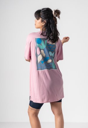 Rosa T-Shirt mit kurzen Ärmeln, das auf der Rückseite ein farbenfrohes abstraktes Design zeigt, mit Farbtönen von Blau, Grün und beige Formen und Linien.