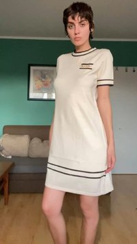 Vestido de manga curta em creme com riscas horizontais pretas, um detalhe de bolso subtil e um corte descontraído, feito de um tecido leve.