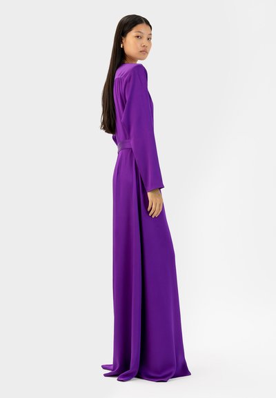 Paarse jurk met lange mouwen en een ontspannen silhouet, met een ceintuur in de taille en vloeiende stof. Glad textuur en minimalistisch ontwerp.
