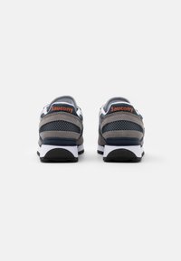 Sneakers Saucony con una toma aerea in mesh grigio e blu navy, colletto imbottito e suola intermedia bianca. Presentano il marchio arancione sul tallone. Suola nera texturizzata.