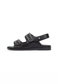 Sandalias de cuero negro con dos correas ajustables, costuras decorativas, diseño de punta abierta y suela plana de goma.