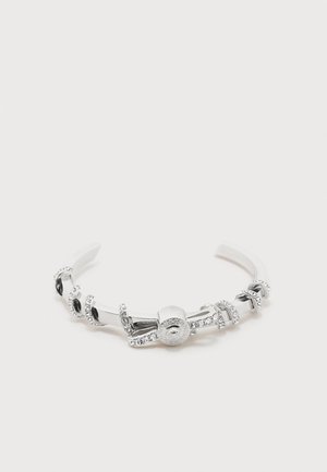 Brățară tip manșetă din metal argintiu cu cristale clare integrate și o închizătoare rotundă decorativă, cu modele detaliate.