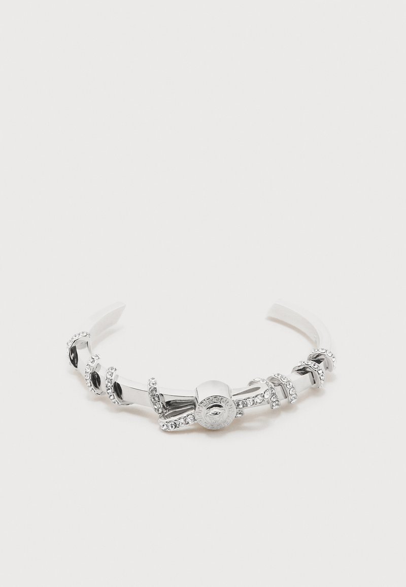 Ασημένιο μεταλλικό βραχιόλι cuff με ενσωματωμένα διαυγή κρυστάλλινα στοιχεία και στρογγυλό διακοσμητικό κούμπωμα με περίτεχνα σχέδια.