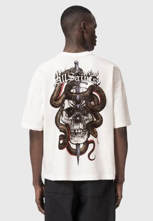 Mand iført hvid T-shirt med grafik af kranium, slange viklet om dolk og teksten "AllSaints" på ryggen.