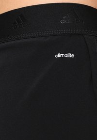 Černé sportovní šortky s hladkou texturou, elastickým pasem s logem 'adidas' a bílým nápisem 'climalite'.