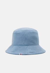 Chapeau seau bleu clair en tissu texturé. Il possède un large bord et une petite étiquette de logo sur le côté.