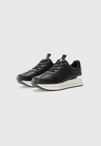 Black sneakers with a smooth leather upper, rounded toe, and contrasting white sole. Features laces, a heel pull tab, and metallic accents.