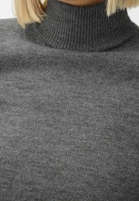 Szary sweter z golfem wykonany z miękkiej, prążkowanej dzianiny. Posiada wysoki kołnierz i gładką teksturę na całej powierzchni.