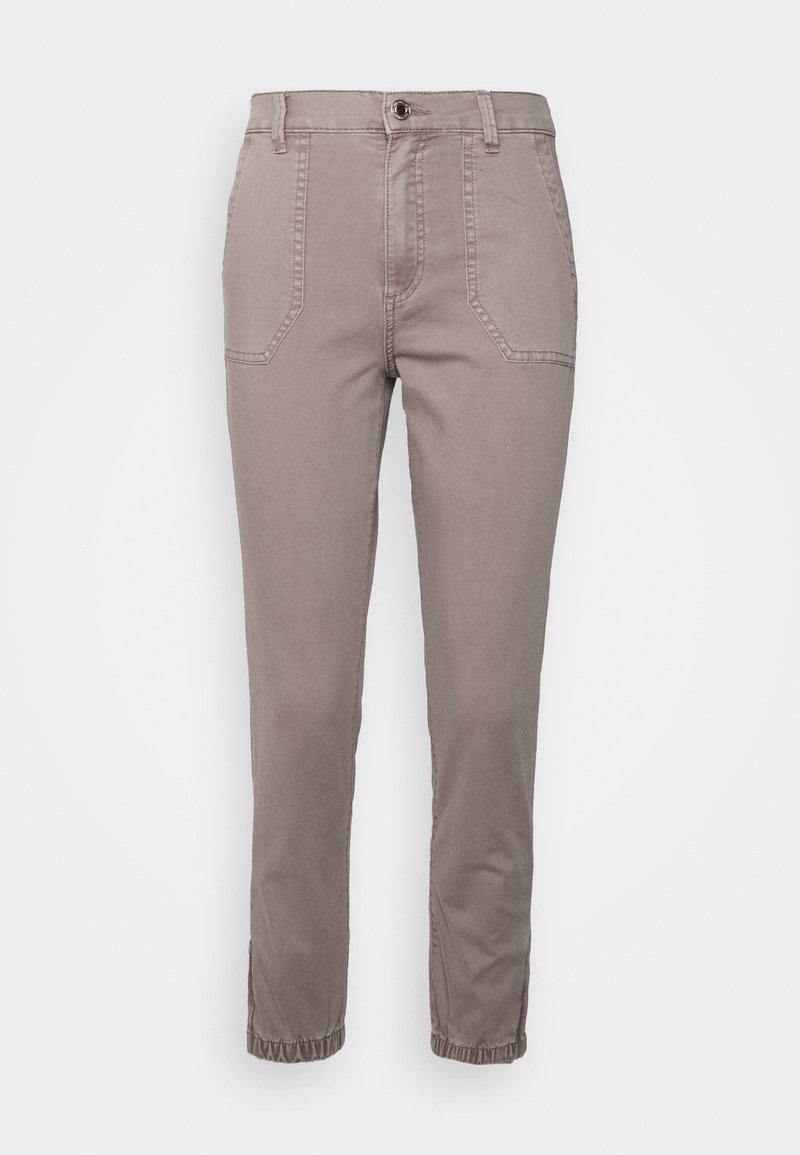 Pantalon beige fuselé avec poches plaquées devant, fermeture par bouton et zip, passants pour ceinture et poignets élastiques aux chevilles.