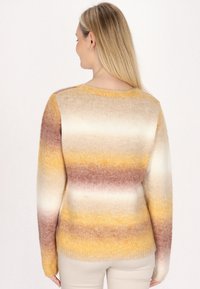 Pulover tricotat în nuanțe gradient de galben, alb și maro, având un guler rotund și mâneci lungi cu manșete cilindrice.