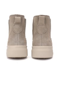Stivaletti ankle in suede grigio con una finitura testurizzata, dotati di una linguetta sul retro e di una robusta suola piattaforma beige.