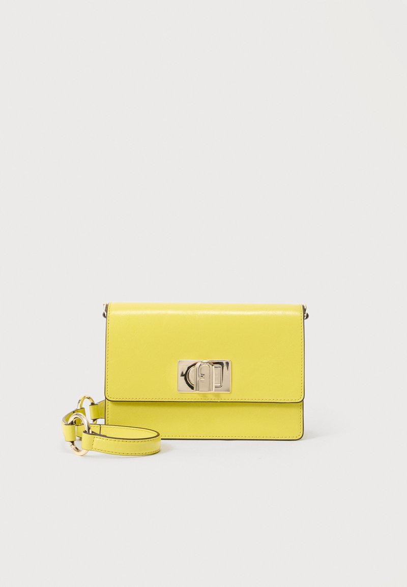 Κίτρινη δερμάτινη τσάντα χιαστί με χρυσό ορθογώνιο κούμπωμα και ρυθμιζόμενο λουράκι σε λευκό φόντο.
