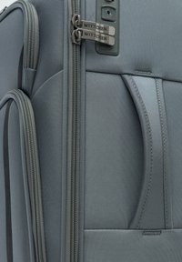 Grau gefärbter Stoffkoffer mit Doppelreißverschlüssen, strukturiertem Oberflächenmaterial, seitlichem Griff und einer Tasche für einfachen Zugriff. Das Logo der Marke WITTCHEN ist sichtbar.