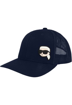 Cappellino trucker in rete blu navy con visiera curva e toppa con un volto di cartone animato con capelli bianchi e occhiali da sole neri sul pannello frontale.