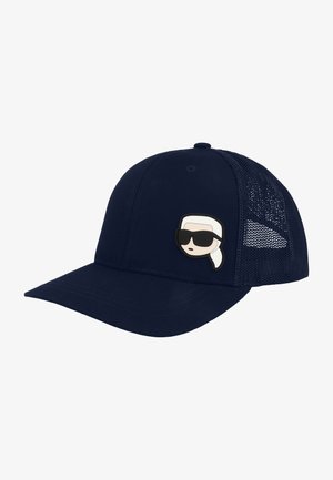 Cappellino trucker in rete blu navy con visiera curva e toppa con un volto di cartone animato con capelli bianchi e occhiali da sole neri sul pannello frontale.