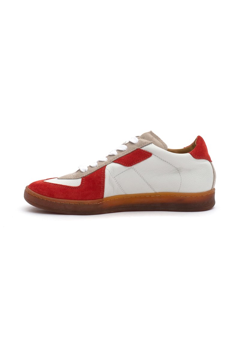 White leather sneaker with red suede accents, beige suede tongue, and white laces. Rubber sole with a slightly transparent finish.