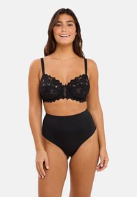 Soutien-gorge en dentelle noire avec armatures, doté de bords festonnés et d'un détail lacé au centre, associé à des culottes taille haute noires unies. Textures lisses.