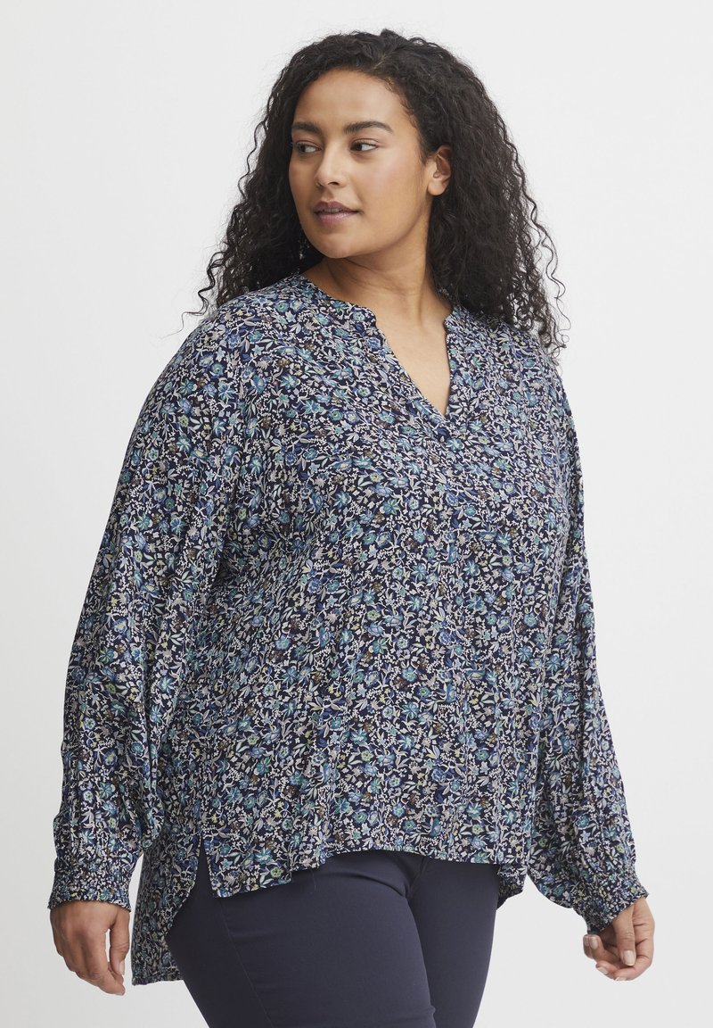 Námornícka kvietková blúzka vyrobená z ľahkej látky, s v-výstrihom, dlhými rukávmi a elastickými manžetami. Kvetinový vzor v odtieňoch modrej a bielej.