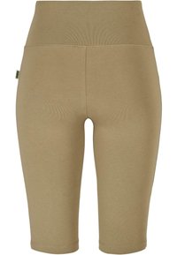 Beige rekbare shorts tot halverwege de bovenbenen met een brede tailleband, gemaakt van zachte, gladde stof, met een naadloos ontwerp en zonder zichtbare hardware.